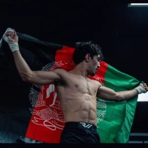 Zaid in MMA holding the Afghanistan flag over his shoulders after a victory.
